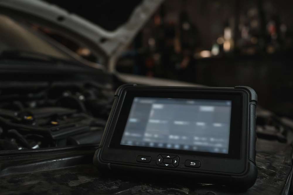 Scan tool beside an open hood